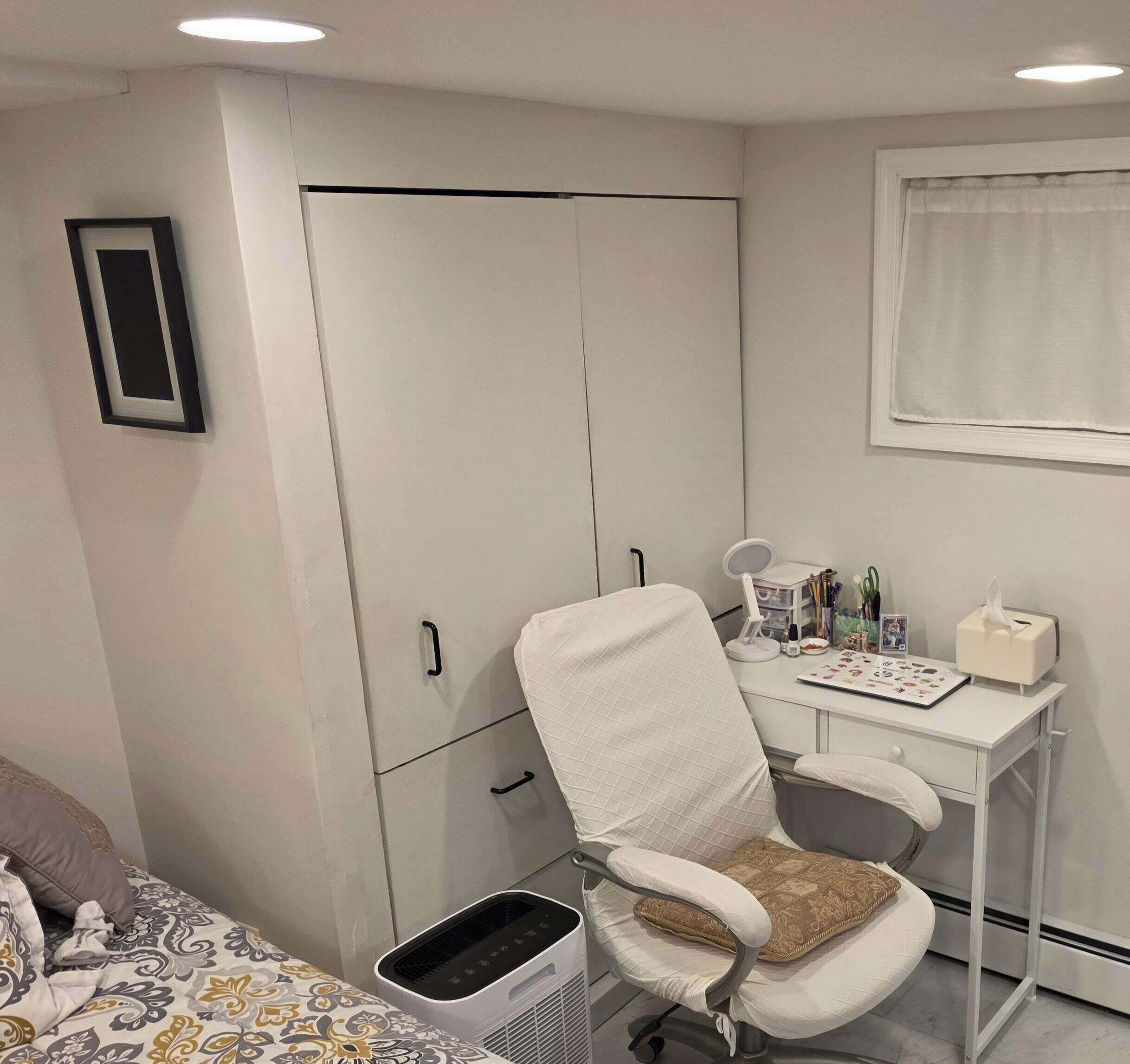 A bedroom with a bed, a desk with a chair, a wardrobe, and a radiator.