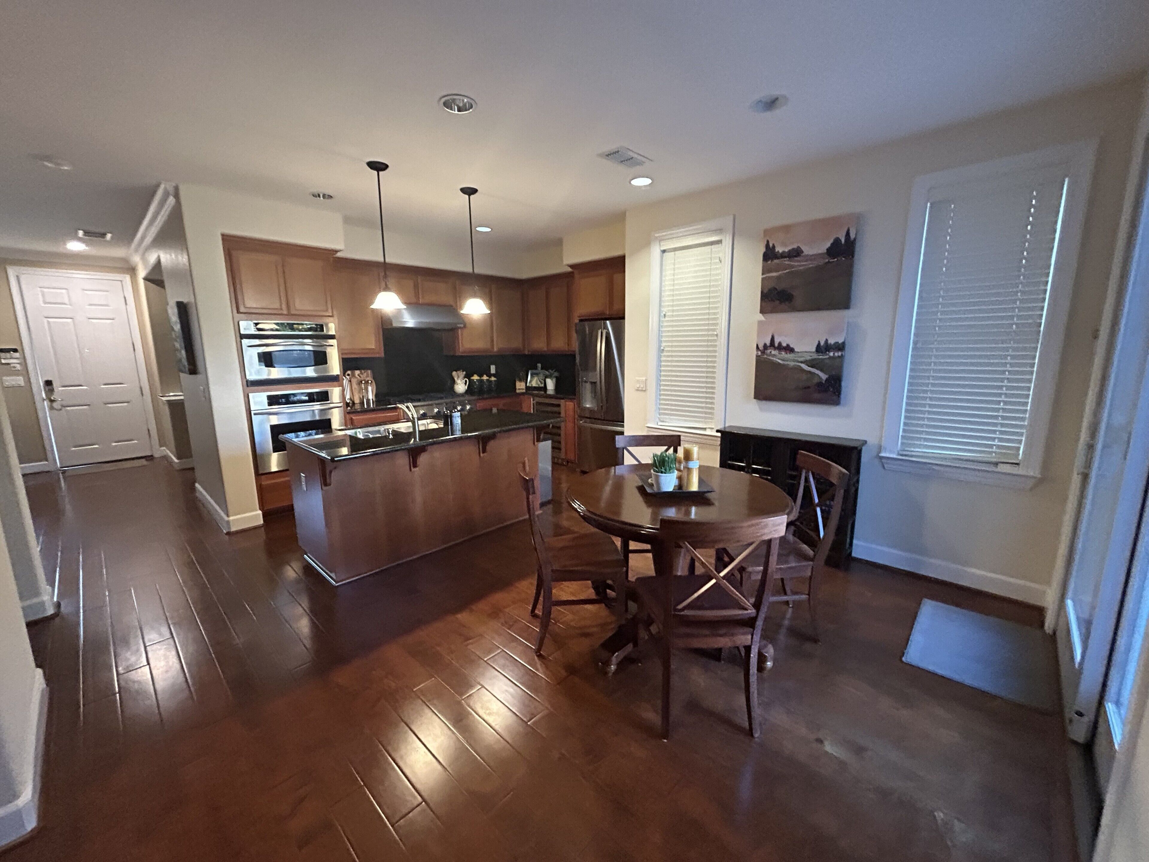 A modern kitchen with wooden cabinets, stainless steel appliances, and a central island.