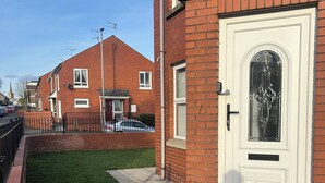 A residential building with a white front door, a small front yard, and a brick facade. - Derry City Apartment (walking distance to city centre and local amenities) (Londonderry)