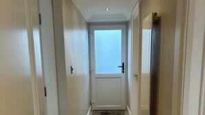 A hallway with a door at the end, recessed lighting, and a window. - Derry City Apartment (walking distance to city centre and local amenities) (Londonderry)