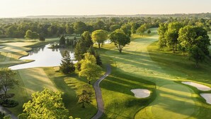 Ein Golfplatz mit Wasserhindernissen, Sandbunkern und einem gewundenen Weg.