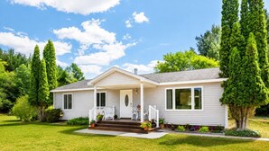A single-story house with a front porch, a small staircase, and a well-maintained lawn. - Private Retreat Near Interlochen Arts| Green Lake (Interlochen)