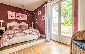 A bedroom with a bed, a nightstand, a window with curtains, and a view of the outdoors. - Gorgeous home in Villamblard (Villamblard)