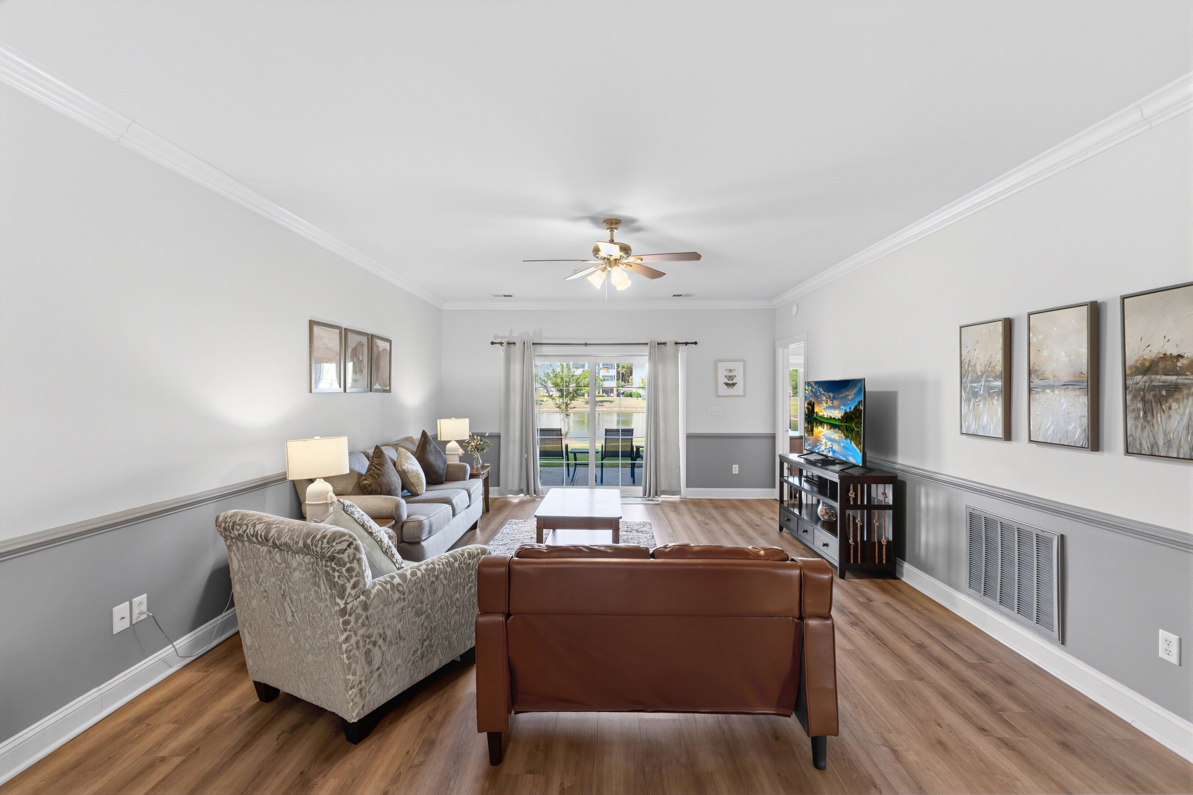 A living room with a sofa, armchair, coffee table, and a TV.
