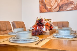 A dining table set with plates, bowls, and a centerpiece of flowers and grapes. - 3BR Brooklyn Flatbush | King Bed, 2 Queens | 5 Min to Kings Theatre (Brookyn)