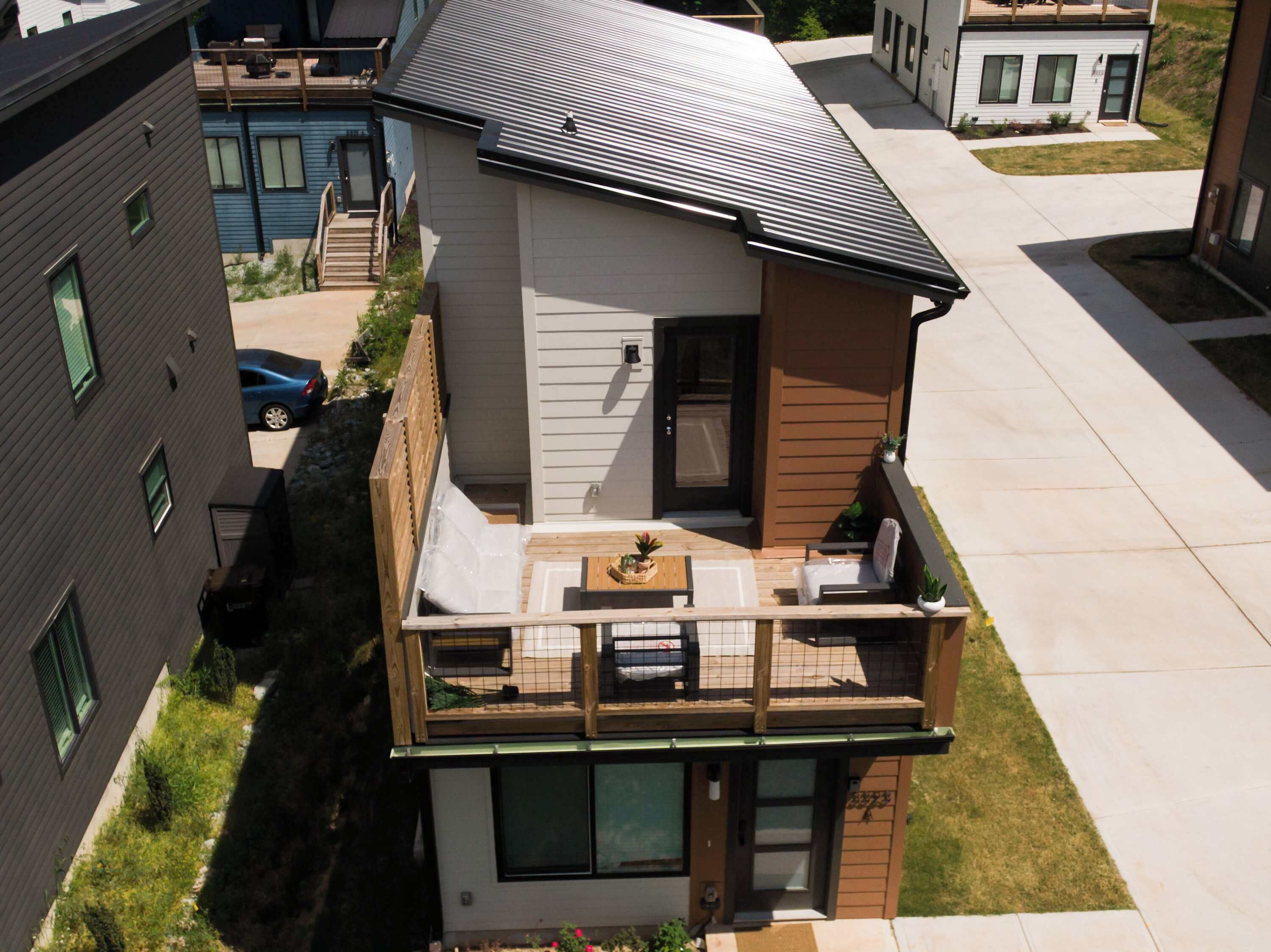A two-story building with a balcony, a front door, and a small porch area.