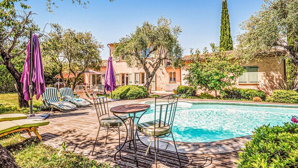 A pool area with lounge chairs, a table, and umbrellas. - Beautiful home in Grasse (Grasse)