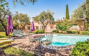 A pool area with lounge chairs, a table, and umbrellas. - Beautiful home in Grasse (Grasse)