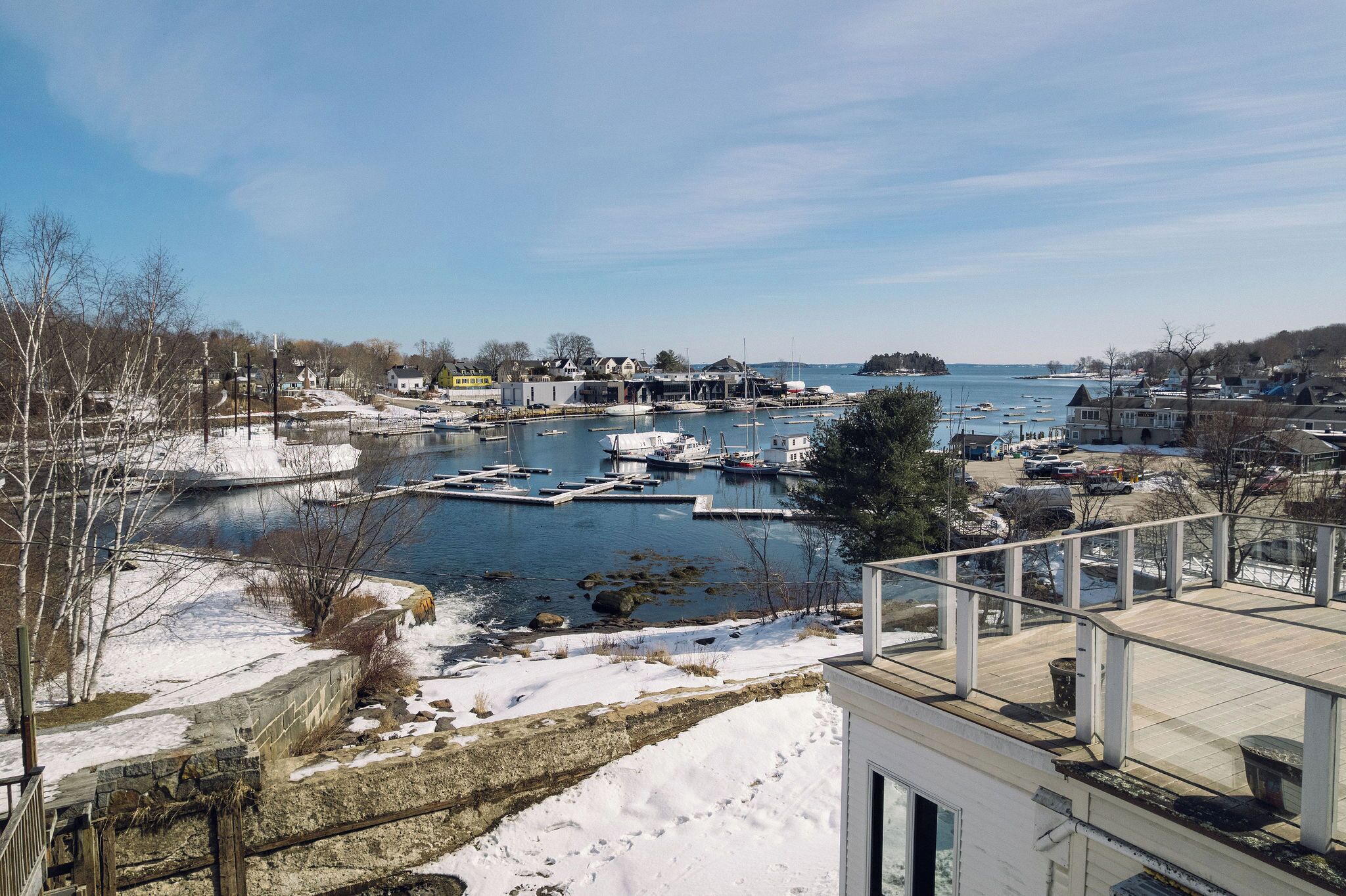 A marina with boats docked, a dock, and a building with a balcony overlooking the water.