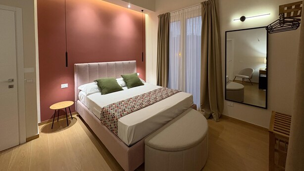 Ein modernes Schlafzimmer mit Bett, Nachttisch und Spiegel.