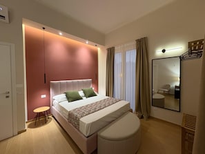 Un dormitorio moderno con cama, mesita de noche y espejo.