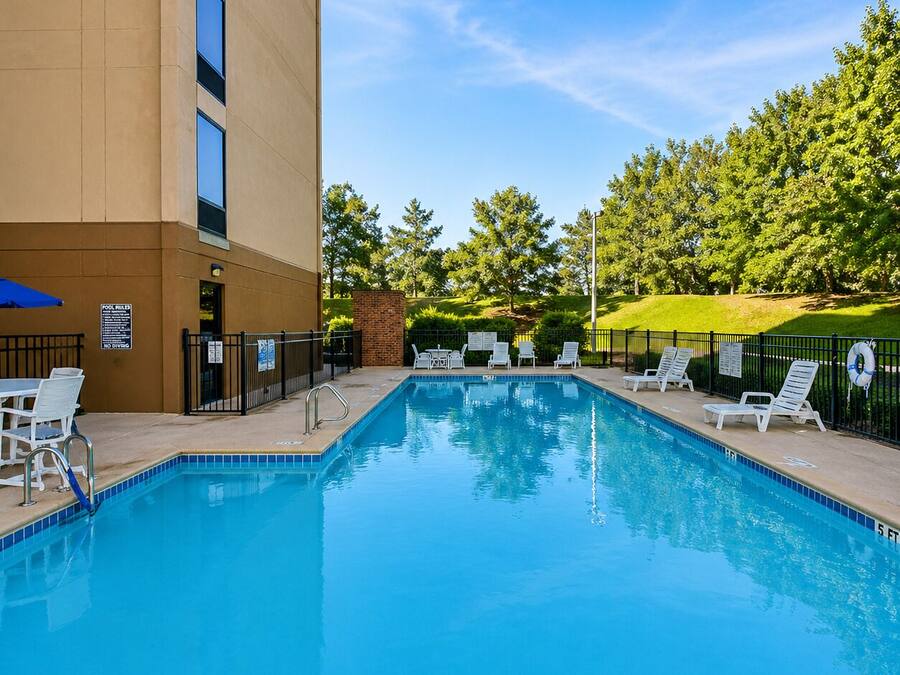 A swimming pool with lounge chairs, a pool table, and a sign indicating no diving.