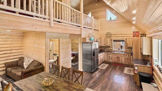 L’intérieur d’une cabane en rondins comprend un coin repas, une cuisine et une chambre à coucher située en mezzanine.