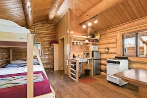 A cabin with a bunk bed, kitchenette, and wooden walls. - Kenai Kuik Cabins - Pink Salmon (Cabin #2) (Soldotna)