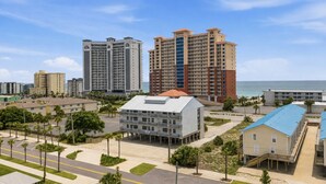 Ein Hotelkomplex an der Küste mit mehreren Hochhäusern, einem zentralen Gebäude mit flachem Dach und Blick auf den Strand.