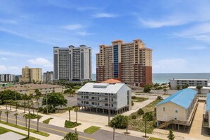 Ein Hotelkomplex an der Küste mit mehreren Hochhäusern, einem zentralen Gebäude mit flachem Dach und Blick auf den Strand.