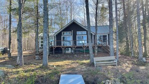 A cabin with a deck, a dock, and a river. - Amazing 4-bedroom cabin in Brownville perfect for your getaway (Brownville)