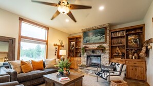 A cozy living room with a fireplace, a sofa, a coffee table, and a bookshelf.