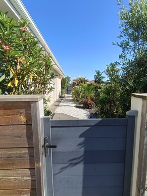 A gated entrance to a property with a pathway leading to a building. - Family house with private heated pool, air conditioning, pool view (Biscarrosse)
