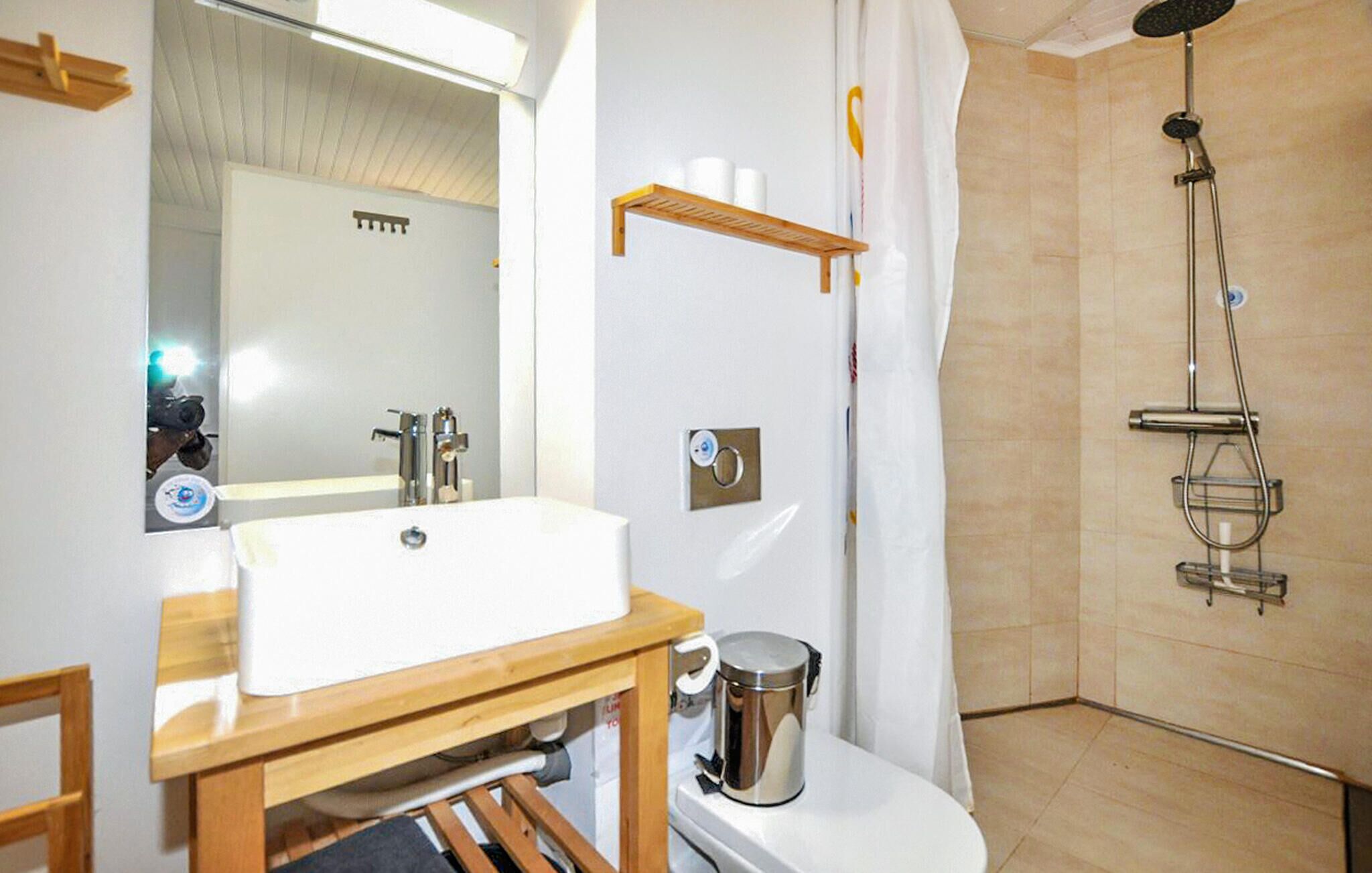 Une salle de bain équipée d’un lavabo, de toilettes, d’une douche et d’un miroir.