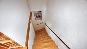 A staircase with wooden steps and a handrail, leading to a landing with a framed picture. - Charmante villa piscine (Taulis)