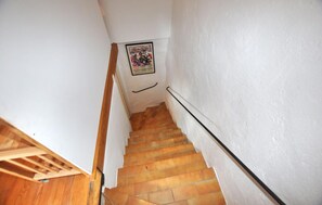 A staircase with wooden steps and a handrail, leading to a landing with a framed picture. - Charmante villa piscine (Taulis)
