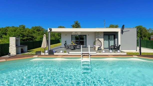 A modern house with a swimming pool, outdoor seating, and a stone feature. - Villa Maki (Istria - Svetvinčenat) (Svetvinčenat)