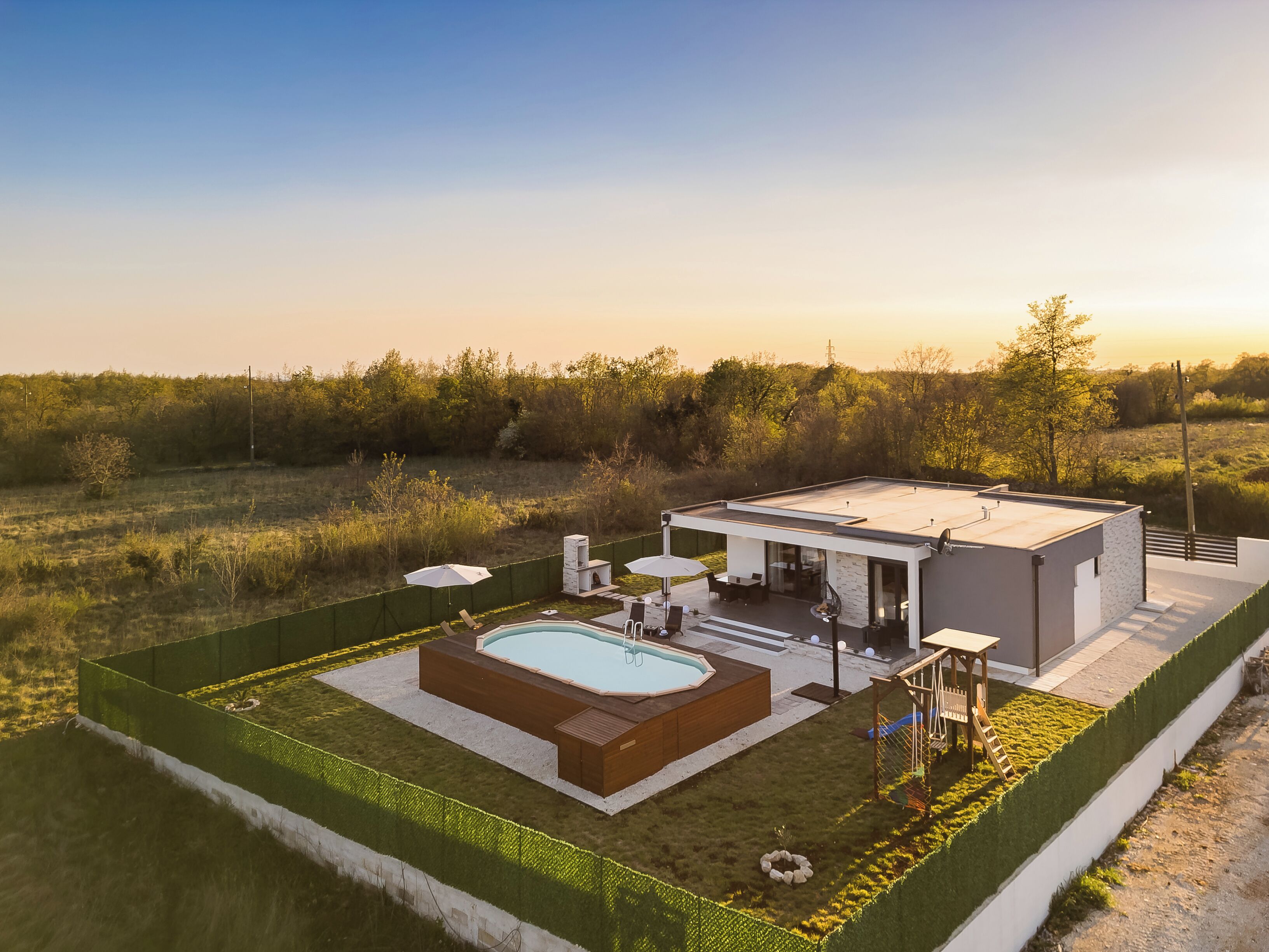 Una casa moderna con piscina, mobiliario exterior y vistas del paisaje circundante.
