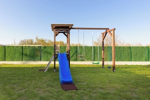 Ein Spielplatz mit Rutsche und Schaukeln.