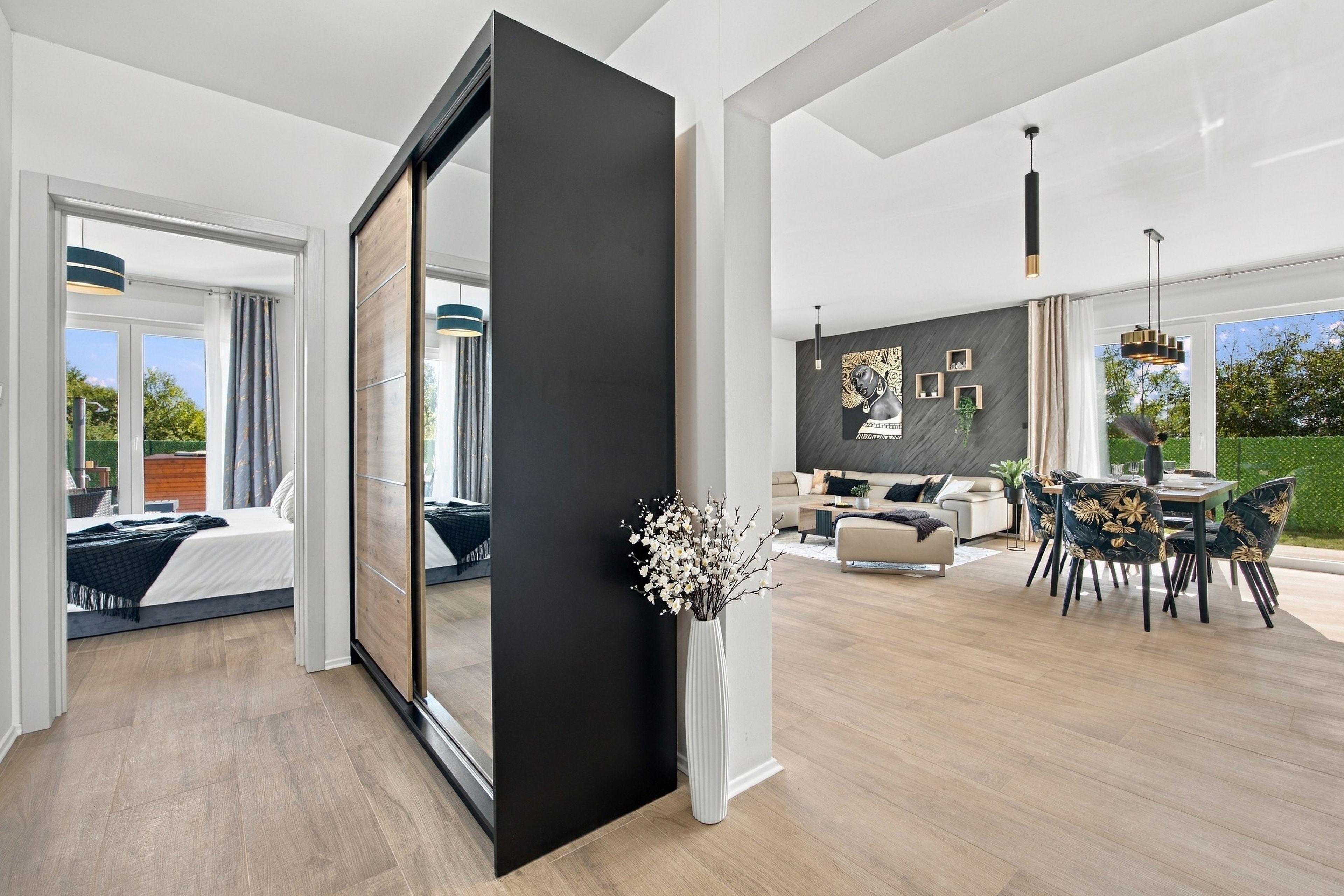 Un interior moderno con un gran puerta corredera, una zona de comedor con mesa y sillas, y una sala de estar con sofá y mesa de centro.