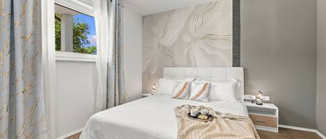 A modern bedroom with a large bed, a bedside table, a nightstand, and a window with curtains.