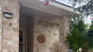 A stone house entrance with a number '31' on the wall, a potted plant, and a small statue. - A cozy, family‑friendly 31TP (Gail)
