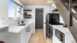 Een moderne keuken met een ingebouwde kookplaat, een spoelbak en een raam met uitzicht op een prachtig panorama.