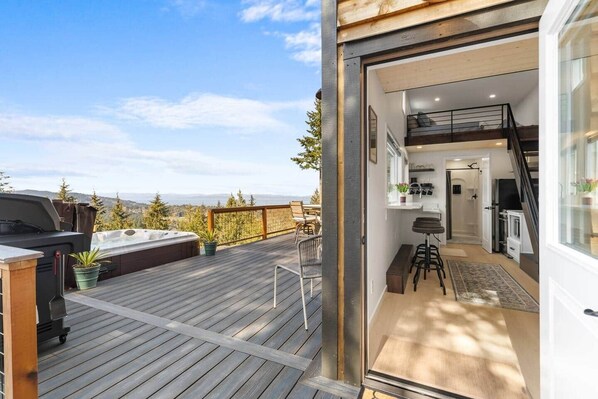 Une terrasse dotée d’un jacuzzi, d’un espace salon extérieur et offrant une vue sur les montagnes.