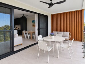 Ein modernes Interieur mit Essbereich, einer Sofagruppe und einem Deckenventilator.