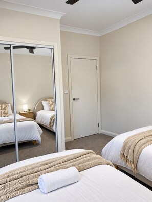 A hotel room with two beds, a large mirror, and a door. - SAND - Walk to Marina I Bay Views I 2 Master Suites (Nelson Bay)