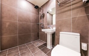 Deluxe kamer | Badkamer | Een douche, een haardroger, handdoeken, zeep