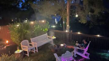 An outdoor seating area with wooden furniture and string lights.