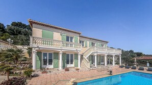 Un bâtiment à deux étages doté d’une piscine, de colonnes et d’un patio couvert.