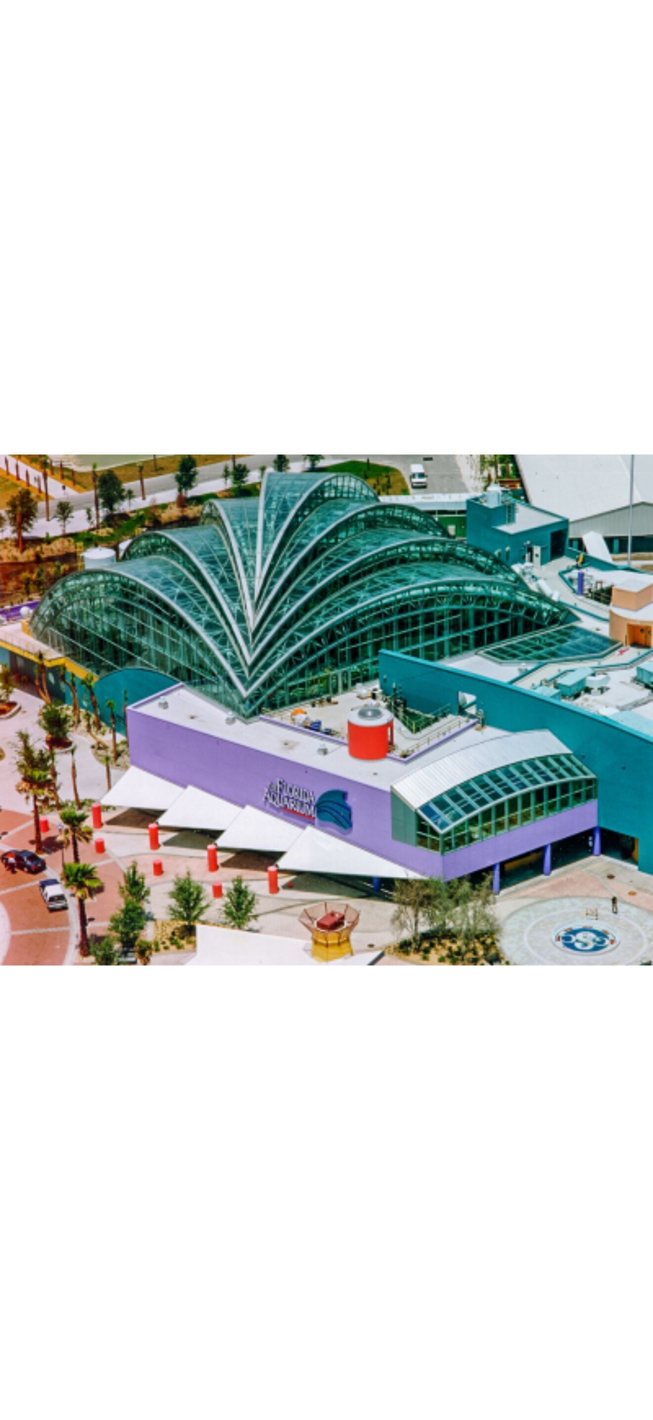 A modern building with a curved glass facade, a purple lower section, and a blue upper section.