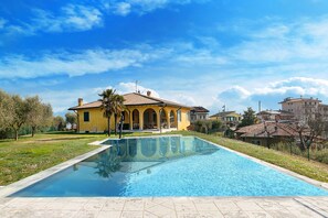 Ein Schwimmbecken mit einem Haus im Hintergrund.