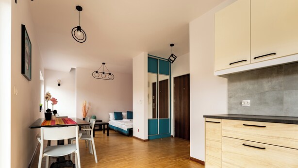 Ein modernes Interieur mit Essbereich, einem Bett und einer Küchenzeile.