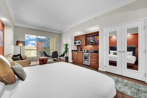 A hotel room with a large bed, a kitchenette, a dining area, and a view of the city. - Luma Vèra –  Strip Luma Vèra – Penthouse Sanctuary Strip Views (Las Vegas)