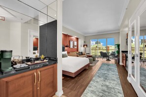Een moderne hotelkamer met een groot bed, een bureau, een zithoek en uitzicht op de stad.