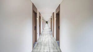 Un long couloir étroit, avec des portes des deux côtés, menant à différentes pièces.