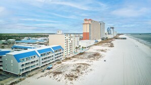 Un hôtel situé sur la côte, composé de plusieurs bâtiments, avec une plage et une jetée.