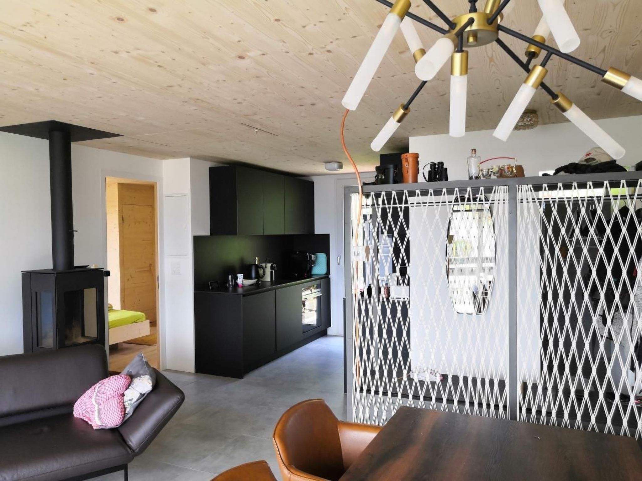 Un espace de vie moderne comprenant un canapé, une table à manger, un coin cuisine et une cheminée.