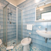 Baño con ducha, bidé, lavabo e inodoro.
