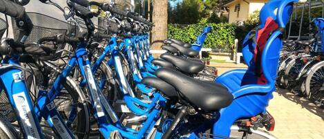 A row of blue bicycles parked in a designated area.