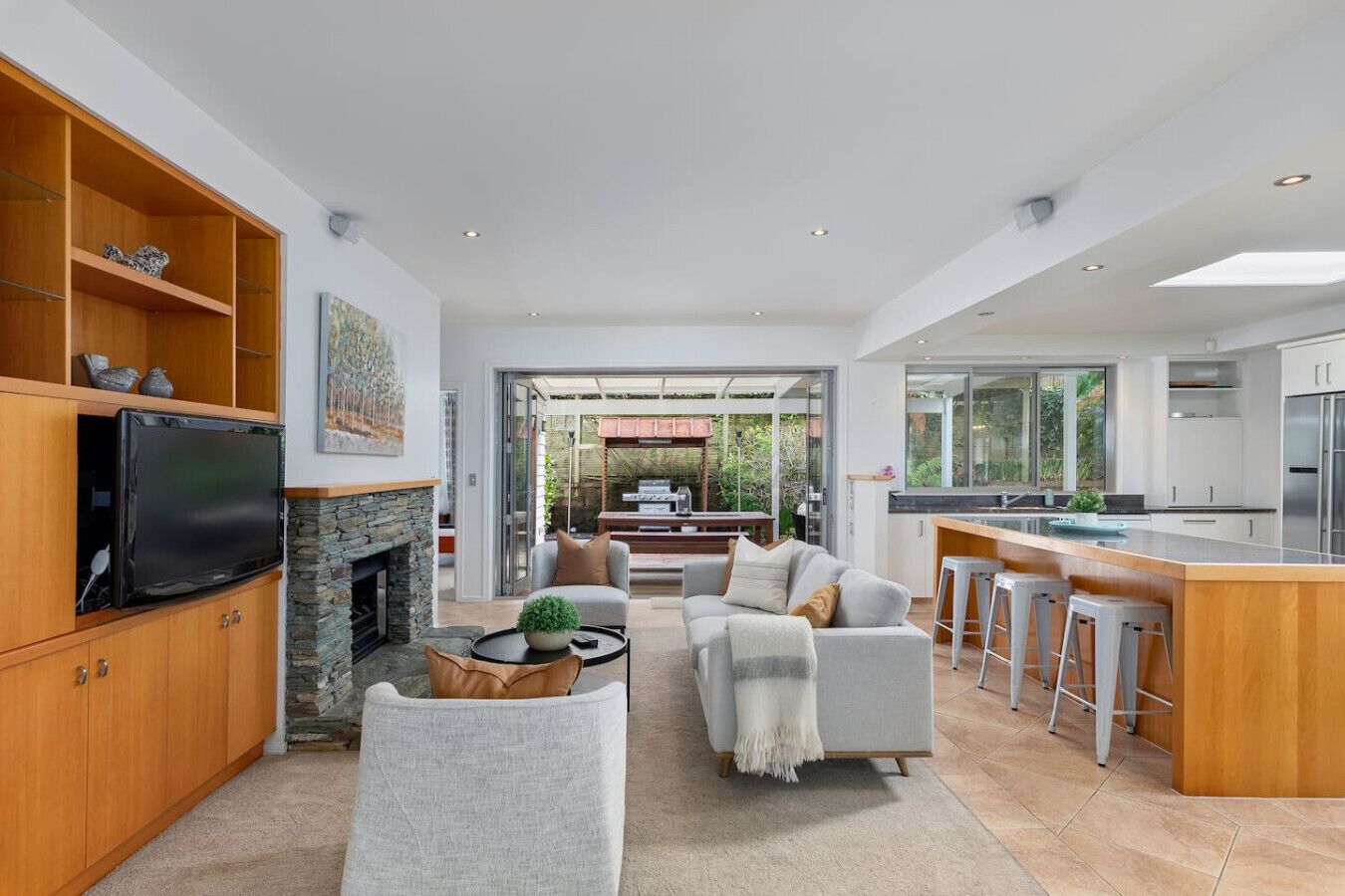 Open plan living, dining and kitchen, with doors leading out to a covered outdoor dining and BBQ area